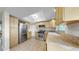 Well-lit kitchen with stainless steel appliances, wood cabinets, tiled flooring, and ample counter space at 11460 Park Blvd, Seminole, FL 33772