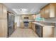 Well-lit kitchen features stainless steel appliances, natural wood cabinets and tile flooring at 11460 Park Blvd, Seminole, FL 33772