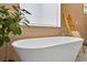 Close-up of a modern soaking tub with sleek fixtures and a wooden ladder for towels at 131 Forest Hills Dr, Redington Shores, FL 33708