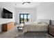 Bright bedroom featuring a gray bed, a dresser, and sliding doors with natural light at 131 Forest Hills Dr, Redington Shores, FL 33708