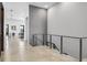 Upstairs hallway view showcasing modern railing, access to the living room, and ample natural light at 131 Forest Hills Dr, Redington Shores, FL 33708