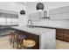 Contemporary kitchen featuring a waterfall island, designer stools, and stainless steel appliances at 131 Forest Hills Dr, Redington Shores, FL 33708