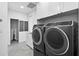 Well-equipped laundry room with front-load machines and ample storage at 131 Forest Hills Dr, Redington Shores, FL 33708