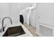 Bright laundry area with stainless steel sink, white cabinetry and storage at 131 Forest Hills Dr, Redington Shores, FL 33708