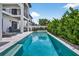 Stunning pool area with a long in-ground pool and a built-in hot tub at 131 Forest Hills Dr, Redington Shores, FL 33708