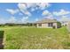 Expansive backyard featuring green grass and a view of the home's exterior and surrounding landscape at 13304 Mylion Way, Spring Hill, FL 34610