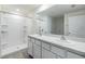 Clean bathroom featuring double sinks, white cabinetry, and a walk-in shower at 13304 Mylion Way, Spring Hill, FL 34610