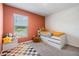 Modern bedroom featuring a colorful wall, large window, and plush carpet at 13304 Mylion Way, Spring Hill, FL 34610
