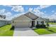 Charming single-story home featuring a two-car garage, manicured lawn, and inviting entrance with decorative wreath at 13304 Mylion Way, Spring Hill, FL 34610