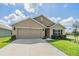 Charming single-story home featuring a well-manicured lawn, two car garage and neutral-colored exterior at 13304 Mylion Way, Spring Hill, FL 34610
