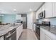 Modern kitchen with granite counters, stainless appliances, and tile flooring at 13304 Mylion Way, Spring Hill, FL 34610