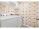 Bright laundry room featuring a white washer and dryer along with wallpaper with a sun pattern at 13304 Mylion Way, Spring Hill, FL 34610
