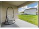 Covered patio with hanging chair overlooking a fenced backyard at 13304 Mylion Way, Spring Hill, FL 34610