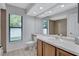 Well-lit bathroom with a single sink vanity, large mirror, and tiled shower at 134 Barrington Dr, Brandon, FL 33511