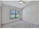 Inviting bedroom featuring neutral carpet, a ceiling fan, and a window with backyard view at 134 Barrington Dr, Brandon, FL 33511