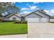 Charming single-story home featuring a three car garage, landscaped yard and freshly cut lawn at 134 Barrington Dr, Brandon, FL 33511