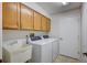 Functional laundry area with washer, dryer, sink, and cabinets for ample storage at 134 Barrington Dr, Brandon, FL 33511