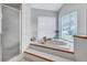 Bright bathroom features large soaking tub, shower and window at 134 Barrington Dr, Brandon, FL 33511