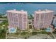 Stunning aerial view of the pink luxury condo complex with pools, lush landscaping and ocean views at 1340 Gulf Blvd # 8C, Clearwater Beach, FL 33767
