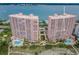 Aerial view showcasing pink condo buildings with beach access and a community pool at 1340 Gulf Blvd # 8C, Clearwater Beach, FL 33767