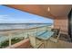 Balcony with a table and chairs overlooking a sandy beach with ocean views at 1340 Gulf Blvd # 8C, Clearwater Beach, FL 33767