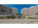 Entrance to a high-rise condominium community with well-manicured landscaping and palm trees at 1340 Gulf Blvd # 8C, Clearwater Beach, FL 33767