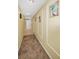 Hallway with tile flooring, decorative wall trim and beach themed artwork leads to the entrance at 1340 Gulf Blvd # 8C, Clearwater Beach, FL 33767