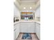 Bright kitchen features white cabinetry, tile backsplash, and a pass-through to the living area with ocean views at 1340 Gulf Blvd # 8C, Clearwater Beach, FL 33767