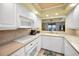 Well-lit kitchen featuring white appliances and cabinetry, with a pass-through offering picturesque ocean views at 1340 Gulf Blvd # 8C, Clearwater Beach, FL 33767