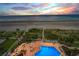 Resort-style pool and lounging area with beach views and a beautiful sunset at 1340 Gulf Blvd # 8C, Clearwater Beach, FL 33767