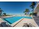 Beautiful community pool with palm trees, lounge chairs, and beach access at 1340 Gulf Blvd # 8C, Clearwater Beach, FL 33767