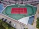 Aerial view of a vibrant tennis court with updated colors next to parking and landscaping at 1340 Gulf Blvd # 8C, Clearwater Beach, FL 33767
