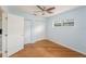 Well-lit bedroom featuring light blue walls, wood flooring, ceiling fan, and closet, offering a bright atmosphere at 1517 60Th S St, Gulfport, FL 33707