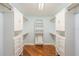 Walk-in closet with custom shelving, cabinets, drawers and wood-look flooring at 1517 60Th S St, Gulfport, FL 33707