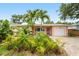 Charming single-story home with a lush front yard, palm trees, brick driveway, and a one-car garage at 1517 60Th S St, Gulfport, FL 33707