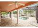 Screened-in patio with brick pavers, white columns, ceiling fans, and a sparkling pool with palm tree views at 1517 60Th S St, Gulfport, FL 33707