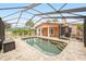 Backyard with a screened-in pool, brick pavers, and tropical landscaping for private outdoor living at 1517 60Th S St, Gulfport, FL 33707
