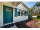 Up-close view of the home's entryway showcasing a stylish blue front door and updated landscaping at 1700 Shore Acres Ne Blvd, St Petersburg, FL 33703