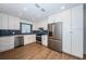 Bright kitchen with stainless steel appliances, white cabinetry, and wood-look floors at 1700 Shore Acres Ne Blvd, St Petersburg, FL 33703