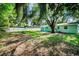 Spacious backyard features a large green lawn, mature trees, new fence, and an area to entertain at 2121 Dodge St, Clearwater, FL 33760
