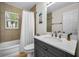 Bathroom featuring tub and shower, new vanity with quartz countertop, and decorative beach-themed accessories at 2121 Dodge St, Clearwater, FL 33760