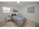 This cozy bedroom features neutral tones, two windows, and a modern art piece, offering a serene retreat at 2121 Dodge St, Clearwater, FL 33760