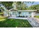 Inviting home with new walkway, green lawn and fresh landscaping with mature palms and plantings at 2121 Dodge St, Clearwater, FL 33760