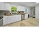 Bright kitchen features white cabinets, stainless steel appliances, and granite countertops at 2121 Dodge St, Clearwater, FL 33760