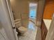 Bathroom with light tile floors, a toilet, and a view to the tub shower at 2210 Bayou Dr, Holiday, FL 34691