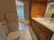 Bathroom with a white sink vanity, wooden cabinets, and a glimpse of the bathtub at 2210 Bayou Dr, Holiday, FL 34691