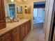 Bathroom featuring wood cabinets, tiled floors, a bathtub and shower, and a large mirror at 2210 Bayou Dr, Holiday, FL 34691