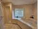 Bathroom with tiled floors, large tub, and mirrored closet doors at 2210 Bayou Dr, Holiday, FL 34691