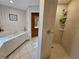 Bathroom featuring tiled floors, a tub, a separate shower, and striped wall paper at 2210 Bayou Dr, Holiday, FL 34691
