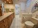 Bathroom with white tile, cabinets, and a glimpse into an adjacent bath area at 2210 Bayou Dr, Holiday, FL 34691